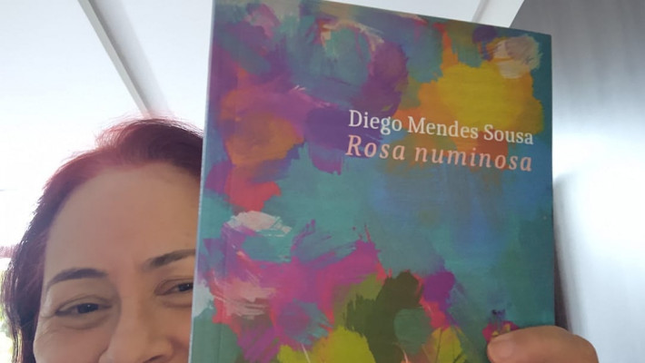 A poeta Noélia Ribeiro com o livro de poemas ROSA NUMINOSA (2022), de Diego Mendes Sousa
